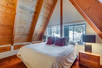 a bedroom with a bed and a large window at Donner Lake Views Rustic Truckee Cabin! in Truckee