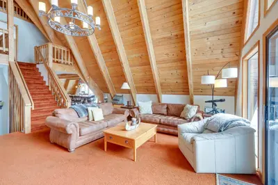 a living room with two couches and a staircase at Donner Lake Views Rustic Truckee Cabin! in Truckee