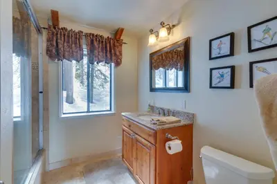 a bathroom with a sink and a toilet and a window at Donner Lake Views Rustic Truckee Cabin! in Truckee