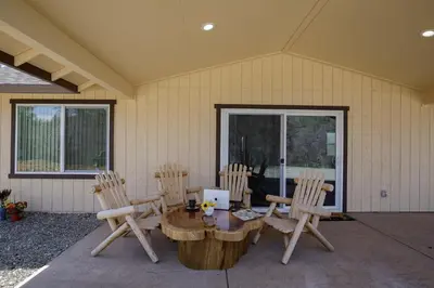 a wooden table and chairs on a patio at Bear Paw Cabin new construction near Yosemite in Mariposa