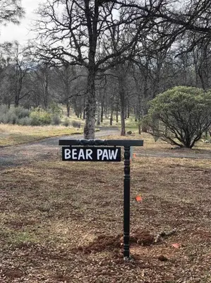 a sign that says bear paw in a park at Bear Paw Cabin new construction near Yosemite in Mariposa