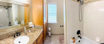 a bathroom with a sink and a mirror and a tub at Serenity in Fresno