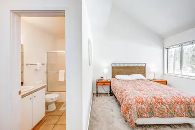 a white bedroom with a bed and a bathroom at Championship Pines in Incline Village