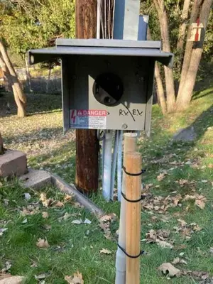 a bird house on a pole in the grass at Forest Cabin by China Creek in Oakhurst