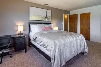 a bedroom with a bed and a desk with a computer at Cherry Cottage 15 min from Yosemite South Entrance in Oakhurst