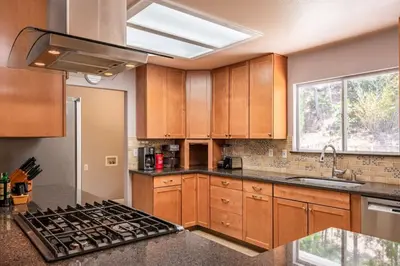 a kitchen with wooden cabinets and a stove top oven at Alpine 4 Bedroom Retreat with Hot tub and Pool table in Coarsegold
