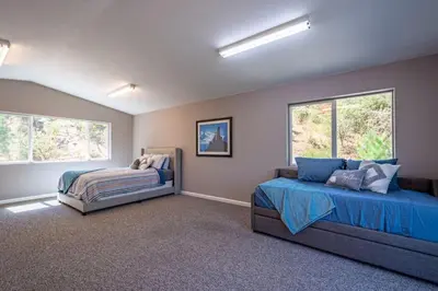 a bedroom with two beds and two windows at Alpine 4 Bedroom Retreat with Hot tub and Pool table in Coarsegold