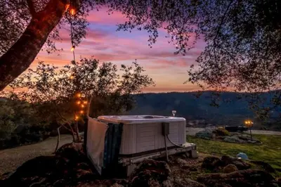 a white tent sitting in the grass under a tree at Fairy Tale 13-acre Sunset Villa at Windy Gap Valley near Yosemite in Ahwahnee