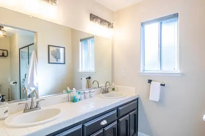 a bathroom with two sinks and a large mirror at Mystic Mountain Villa, 14 miles from Yosemite in Oakhurst