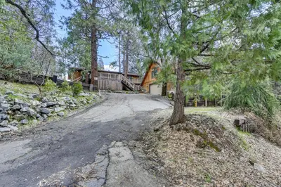 aphalt road with a tree on the side of a house at 9 Mi to Bass Lake Cabin with Fire Pit in Wishon! in Bass Lake Annex