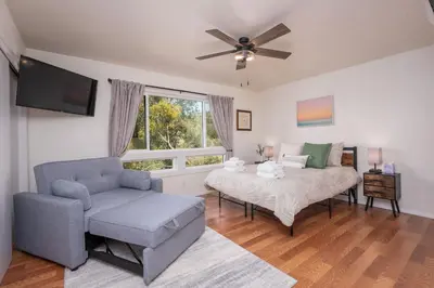 a living room with a couch and a bed at Buckeye Bungalow w hot tub/firepit/views Pet Friendly in Oakhurst