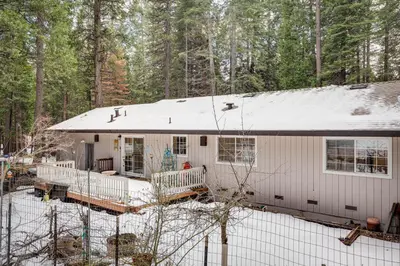 a white house with a snow covered roof at Renovated Pioneer Home in Serene Wooded Setting! in Pioneer