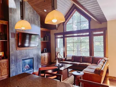 a living room with a couch and a fireplace at Luxury Northstar Home| hot tub| walk to ski lifts in Truckee