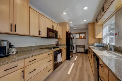 a large kitchen with wooden cabinets and a counter top at Extra Spacious 2BR Cabin w Office and Outdoor Deck in Incline Village