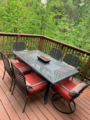 a metal table and chairs on a deck at Harte's Desire Cabin - Lake, A/C, Arcade + in Twain Harte