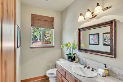 a bathroom with a sink and a mirror and a toilet at Sunny Daze Cabin Luxurious 4BDR with Stunning Views in Kings Beach