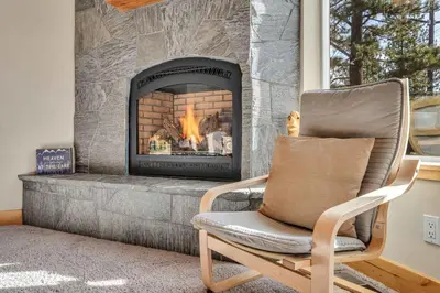a rocking chair in front of a fireplace at Sunny Daze Cabin Luxurious 4BDR with Stunning Views in Kings Beach