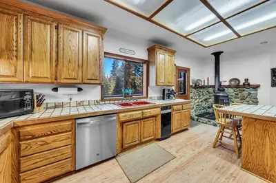 a kitchen with wooden cabinets and a large window at Talmont Pines 4BR Retreat with HOA Beach Access in Tahoe City