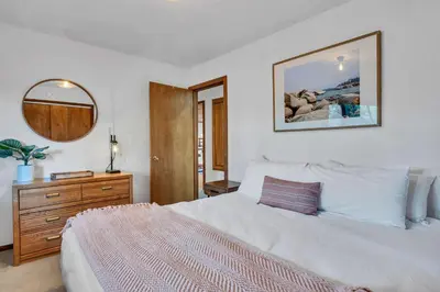 a bedroom with a large white bed and a mirror at Talmont Pines 4BR Retreat with HOA Beach Access in Tahoe City
