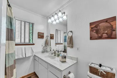 a white bathroom with a sink and a mirror at The Big Bear Chalet Private Hot Tub in Carnelian Bay