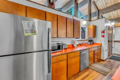 a kitchen with a stainless steel refrigerator and wooden cabinets at Carnelian Bay Retreat with Deck & Bonus Room in Carnelian Bay