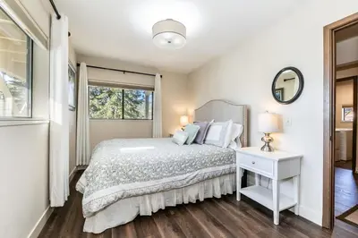 a white bedroom with a bed and a window at Tahoe Vista Retreat with Lake View Walk to beach in Tahoe Vista