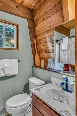 a bathroom with a white toilet and a sink at The Haus of Pine A Vintage Tahoe Cabin in Tahoe City