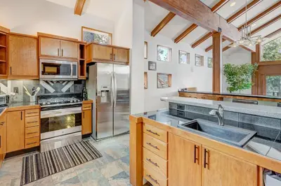 a kitchen with wooden cabinets and a stainless steel refrigerator at Lakeview Hideaway in Kings Beach