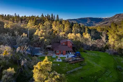 an aerial view of a house in the middle of a field at Sierra Vista Lookout Lodge with Creek, Waterfall and Waterholes, minutes from Bass Lake and Yosemite South Gate in North Fork