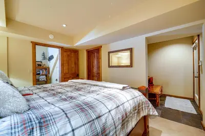 a bedroom with a bed with a plaid blanket at One Moose Lodge with Hot Tub in Tahoe Donner in Truckee