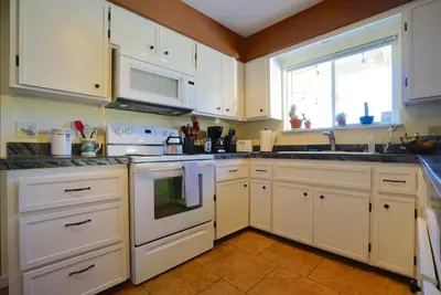 a kitchen with white cabinets and a window at Black Oak Hill Vista near Yosemite - mountain views & starry night sky in Mariposa