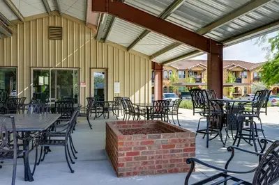 a patio with tables and chairs and a brick fire pit at Charming Patterson Condo with Grilling Stations in Patterson