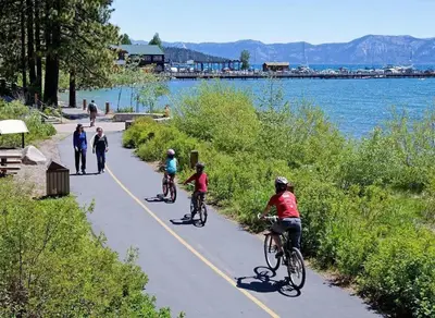 a group of people riding bikes on a path by the water at Rustic and Modern 3BDR Tahoe Cabin in Tahoe City