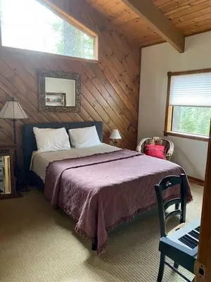a bedroom with a large bed in a wooden room at Gorgeous cabin in BLS with EV Chgr, Pool Access and Gameroom in Arnold