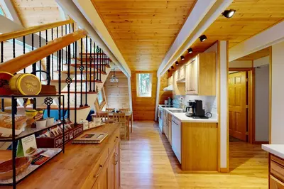 a large kitchen with wooden floors and wooden stairs at Peaceful Pine Getaway in Dorrington