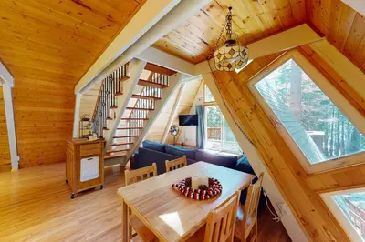 a dining room and living room in a log cabin at Peaceful Pine Getaway in Dorrington