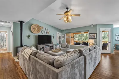 a living room with a large couch and a tv at The Nut House - Lovely Home with Hot Tub home in Groveland