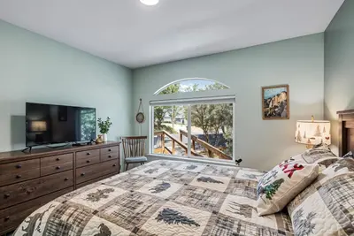 a bedroom with a bed and a tv and a window at The Nut House - Lovely Home with Hot Tub home in Groveland