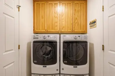 two washing machines in a kitchen with wooden cabinets at The Nut House - Lovely Home with Hot Tub home in Groveland