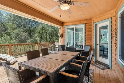 a deck with a wooden table and chairs at The Nut House - Lovely Home with Hot Tub home in Groveland