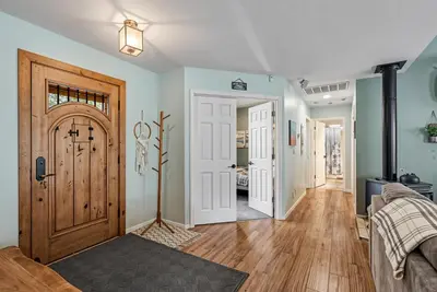a living room with a wooden door and wooden floors at The Nut House - Lovely Home with Hot Tub home in Groveland