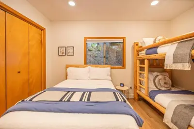 a bedroom with two bunk beds and a window at Corlieu Falls Cabin in Sugar Pine 8 miles from Yosemite with Gazebo, Hot tub a shack and Bar top in Oakhurst