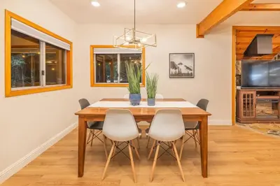 a dining room with a wooden table and chairs at Corlieu Falls Cabin in Sugar Pine 8 miles from Yosemite with Gazebo, Hot tub a shack and Bar top in Oakhurst
