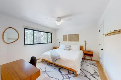 a white bedroom with a bed and a table at Piney Point in Arnold