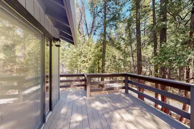 a balcony of a house with a view of the forest at Piney Point in Arnold