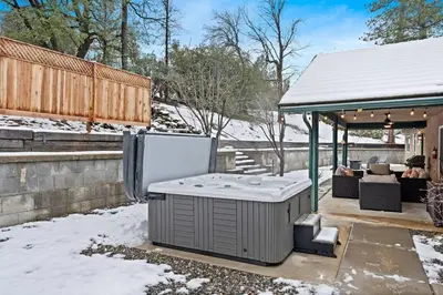 a hot tub sitting under a gazebo in the snow at Country Club Hideout - w/ HotTub, King bed in Oakhurst