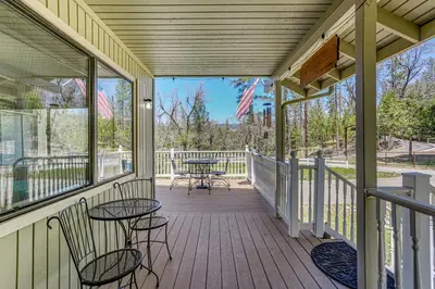 a screened porch with tables and chairs on it at Oakhurst Vacation Rental Near Hiking and Bass Lake! in Oakhurst